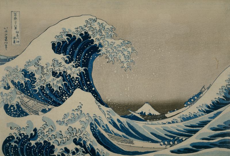 A Japanese ukiyo-e painting with a great wave about to collapse in the middle; at the bottom, to the side of the wave, a boat with some fishermen rows through. In the background, another boat and Mount Fuji in the distance.